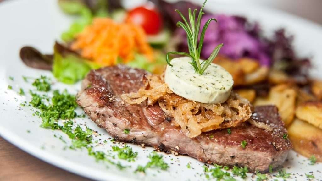 Leckeres Steak mit Kräuterbutter garniert.