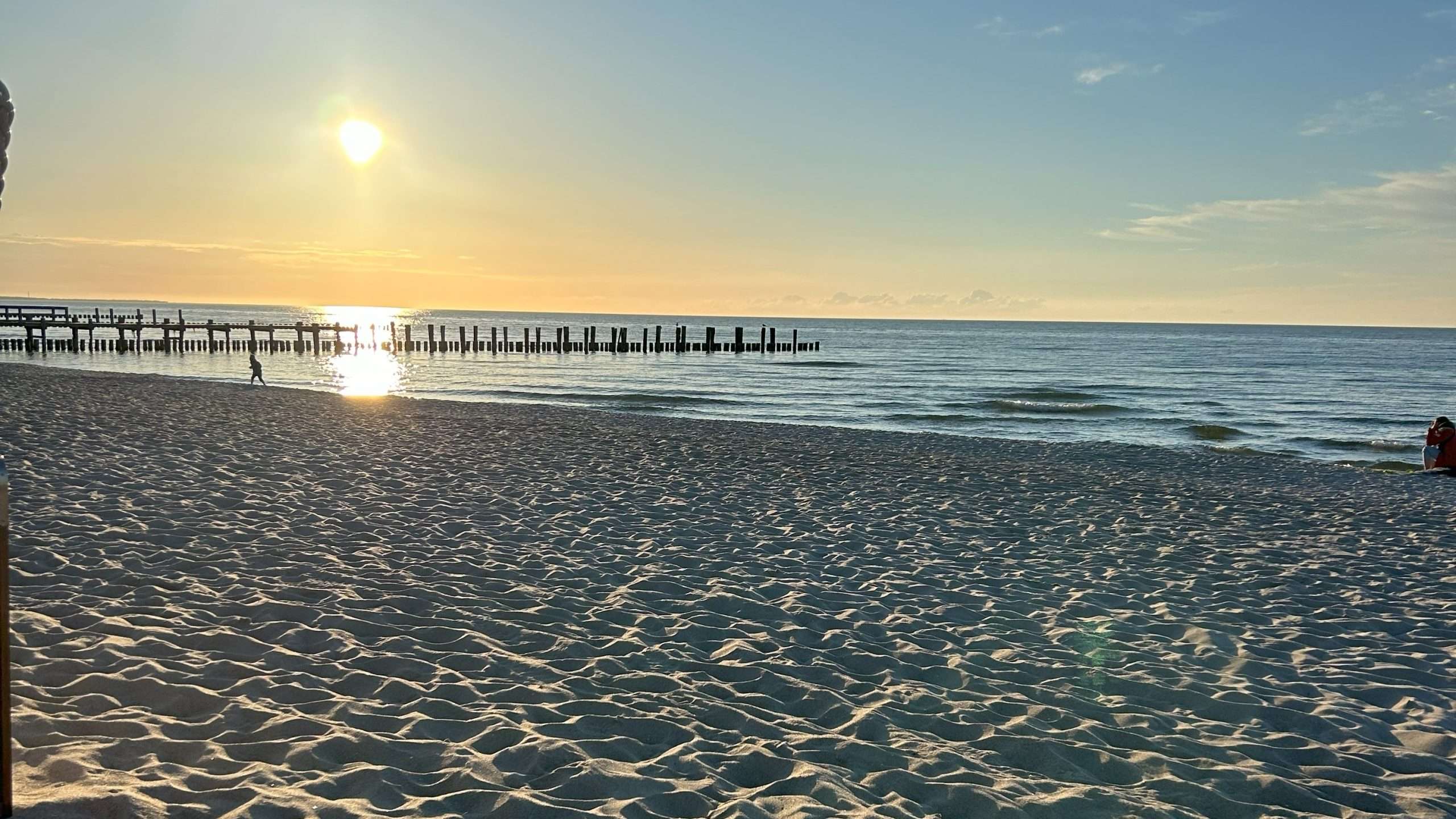 Feinsandiger Strand von Zingst. Die Sonne geht über dem Meer unter.