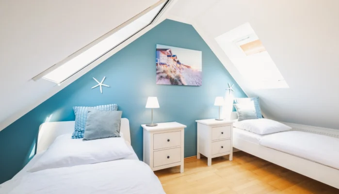 Blick in das Schlafzimmer unter dem Dachgeschoss im Ferienhaus Herzmuschel in Zingst. Man sieht zwei Einzelbetten.