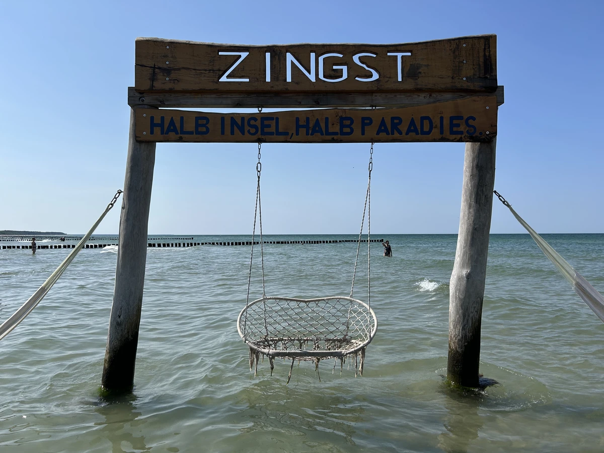 Holzschild im Wasser am Strand von Zingst